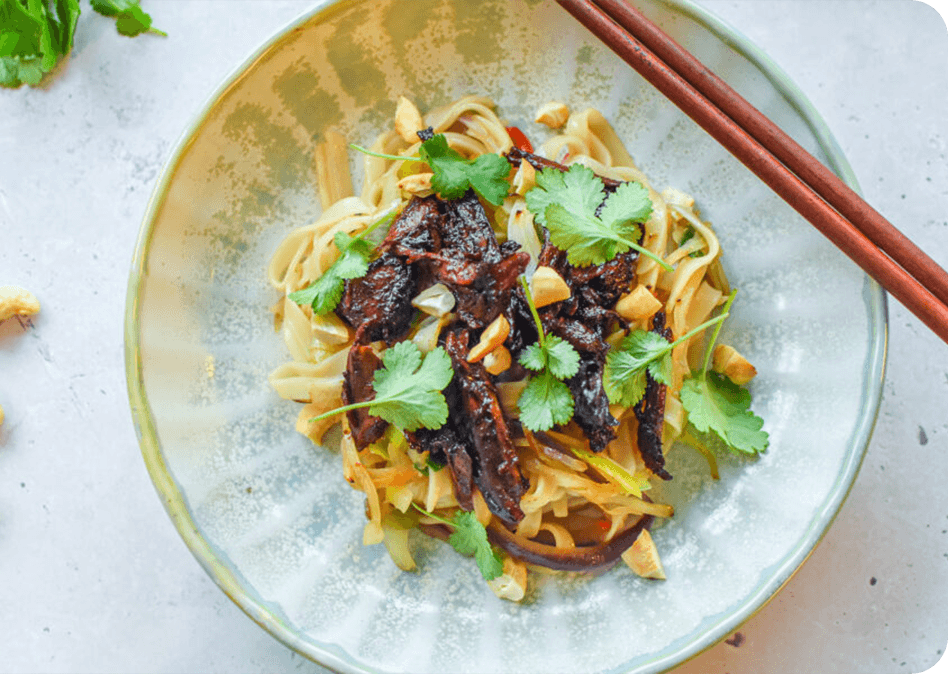 Smaakvolle wok met rijstnoedels, pulled duck en koriander